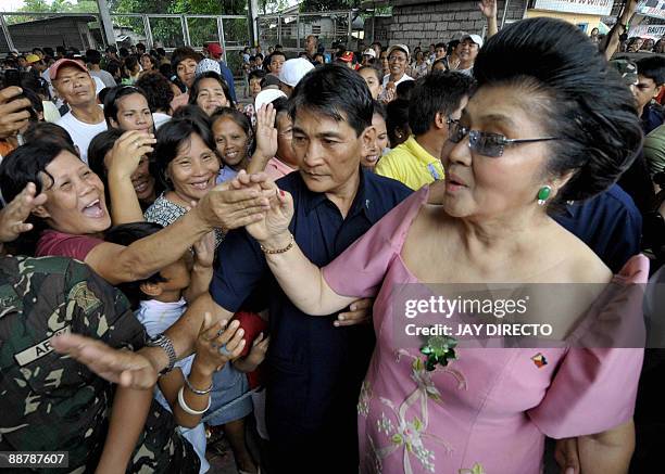 Flamboyant former first lady Imelda Marcos is greeted by supporters as she arrives in the suburban Payatas district, north of Manila to distribute...