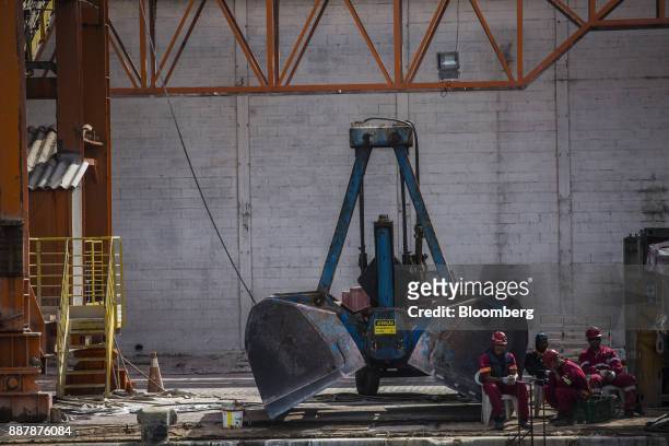 Workers sit in front of a crane on a construction site at the Port of Santos in Santos, Brazil, on Wednesday, Oct. 4, 2017. The port complex is a...