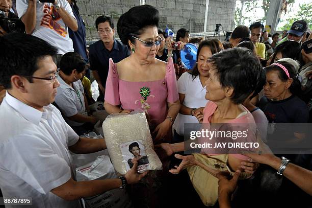 Flamboyant former first lady Imelda Marcos is greeted by supporters as she arrives in the suburban Payatas district, north of Manila to distribute...