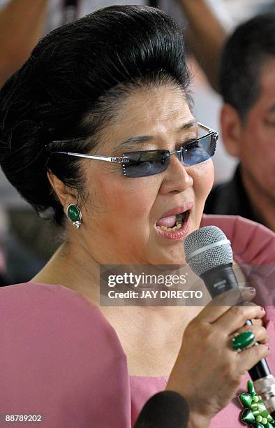 Former first lady Imelda Marcos speaks as she arrives in suburban Payatas district north of Manila to distribute rice to hundreds of poor families on...