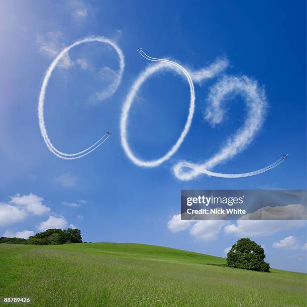co2 written in airstreams over a rural scene - skywriting stock pictures, royalty-free photos & images