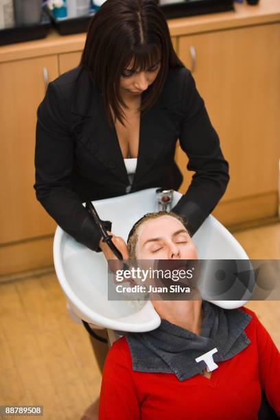 woman getting hair washed by hairdresser  - hair clip - fotografias e filmes do acervo