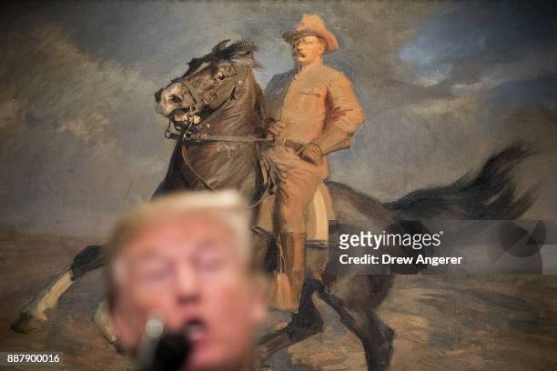 Painting of Teddy Roosevelt hangs behind President Donald Trump as he speaks before signing a proclamation for National Pearl Harbor Remembrance Day,...