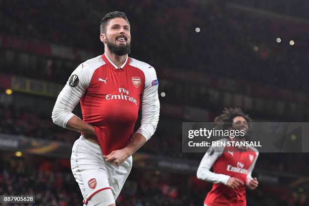 Arsenal's French striker Olivier Giroud pops a ball up his shirt as he celebrates scoring a penalty, the fifth goal, during the Europa League Group H...