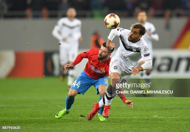 Gabriel Enache of Steaua Bucharest vies with Davide Mariani of Energy Investment Lugano during the UEFA Europa League group G football match FCSB...