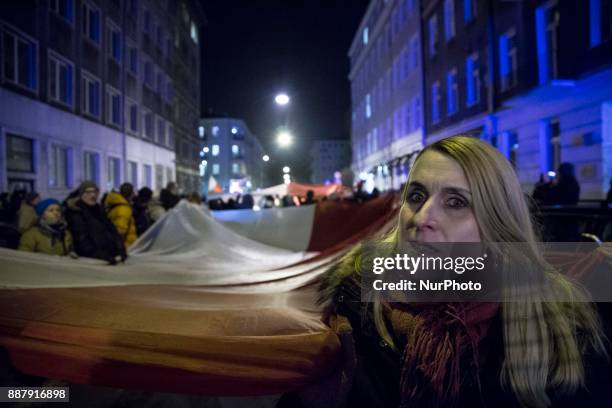 Woman holds polish flag during illegal demonstration near Polish parliament organized by opposition group Obywatele RP in Warsaw on December 7, 2017.