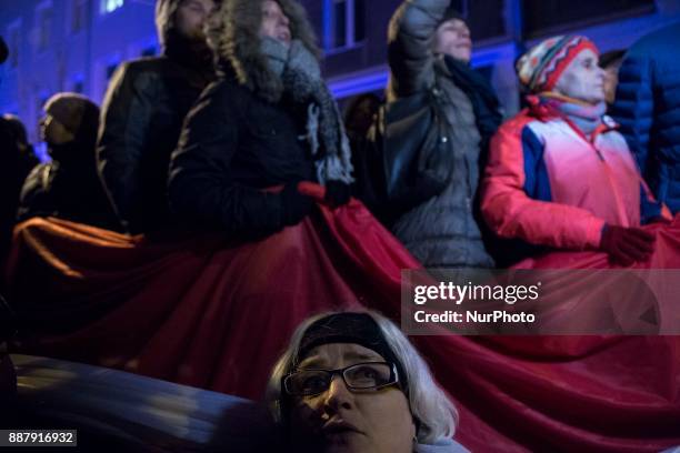 Protesters hold polish flag during illegal demonstration near Polish parliament organized by opposition group Obywatele RP in Warsaw on December 7,...