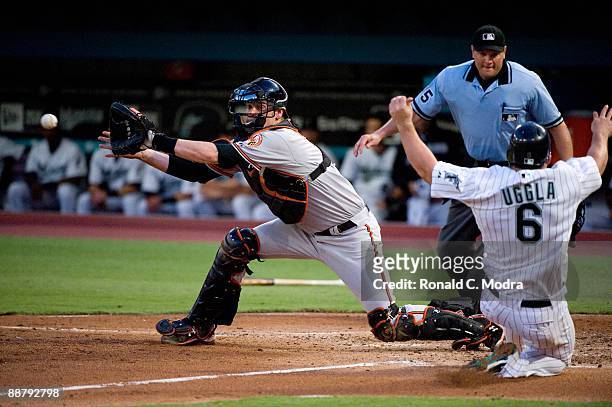 Matt Wieters of the Baltimore Orioles waits for the ball tas Dan Uggla of the Florida Marlins slides into home during a MLB at LandShark Stadium on...