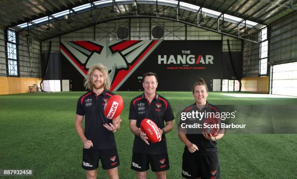 Dyson Heppell, coach John Worsfold and Lauren Morecroft of the Bombers pose at "The Hangar" during an Essendon Bombers Media Announcement & Training...