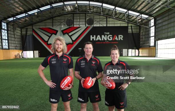 Dyson Heppell, coach John Worsfold and Lauren Morecroft of the Bombers pose at "The Hangar" during an Essendon Bombers Media Announcement & Training...