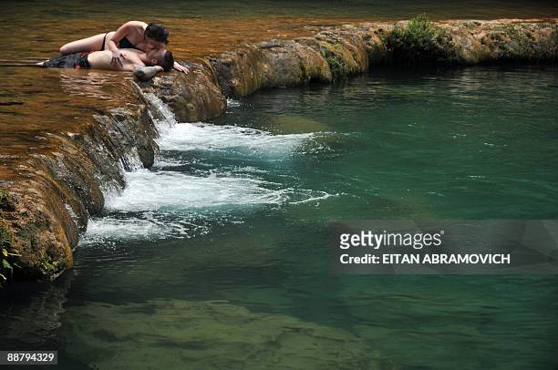 Tourists kiss as they sunbathe in Semuc Champey National Park in the Guatemalan department of Alta Verapaz, on June 28, 2009. The Natural monument of...