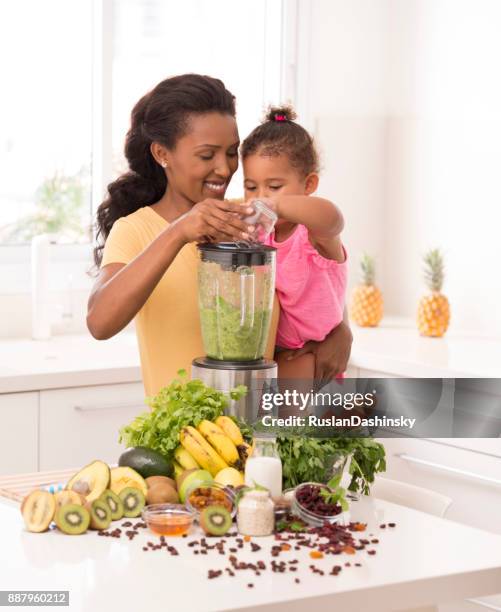 madre con batido fresco haciendo de hija en la cocina - mint plant family fotografías e imágenes de stock