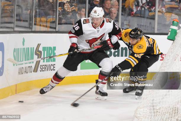 Patrice Bergeron of the Boston Bruins reaches for the loose puck against Christian Fischer of the Arizona Coyotes at the TD Garden on December 7,...
