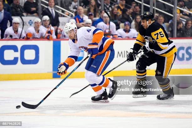 New York Islanders Defenseman Scott Mayfield skates with the puck as Pittsburgh Penguins Right Wing Ryan Reaves chases during the first period in the...