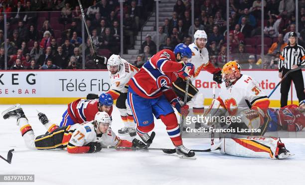 David Rittich of the Calgary Flames makes a save in front of Phillip Danault of the Montreal Canadiens in the NHL game at the Bell Centre on December...