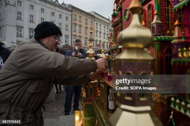 People gather around the Adam Mickiewicz monument to attend the 75th edition of Christmas Cribs. The 'cribs' are nativity scenes, but different from...