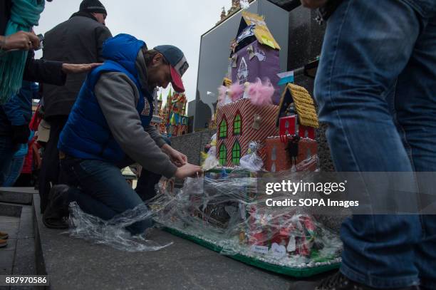 Man unwraps a tower during the 75th edition of Christmas Cribs competition. The 'cribs' are nativity scenes, but different from those elsewhere in...