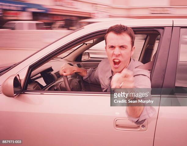 man driving, leaning out of car, pointing angrily (blurred motion) - mancanza di rispetto foto e immagini stock