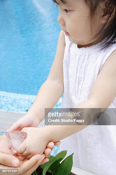 close-up of a baby girl holding at an ice cube - ice cube family 個照片及圖片檔