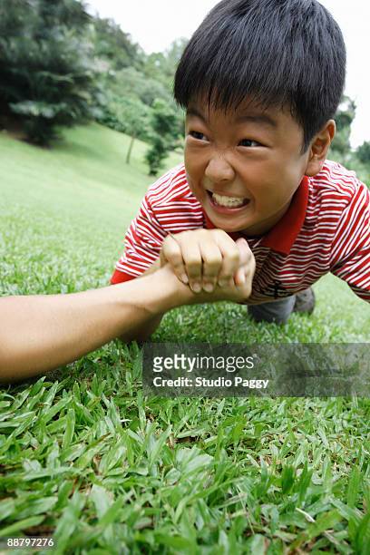 father and son arm wrestling in a park - losing virginity stock pictures, royalty-free photos & images