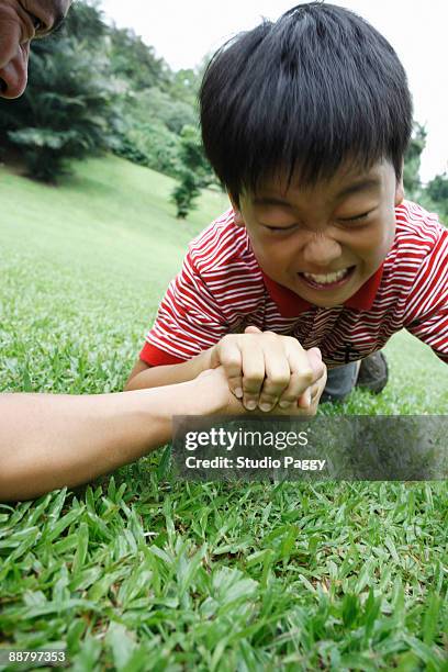 father and son arm wrestling in a park - losing virginity - fotografias e filmes do acervo