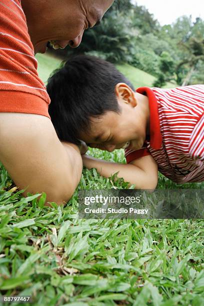 father and son arm wrestling in a park - losing virginity - fotografias e filmes do acervo