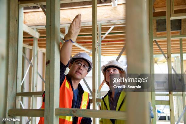 syd112017 diverse construction workers communicating - builder apprenticeship stock pictures, royalty-free photos & images