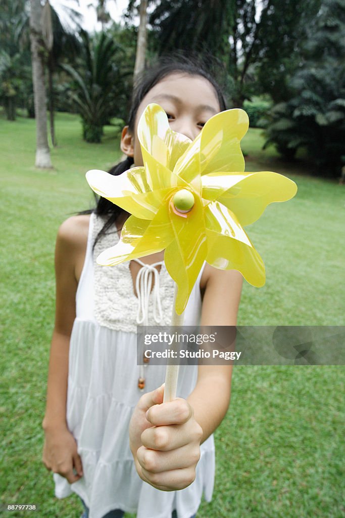 Girl holding a pinwheel in a park