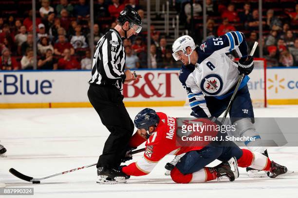 Linesman Devin Berg drops the puck for a face-off between Derek MacKenzie of the Florida Panthers and Mark Scheifele of the Winnipeg Jets at the BB&T...