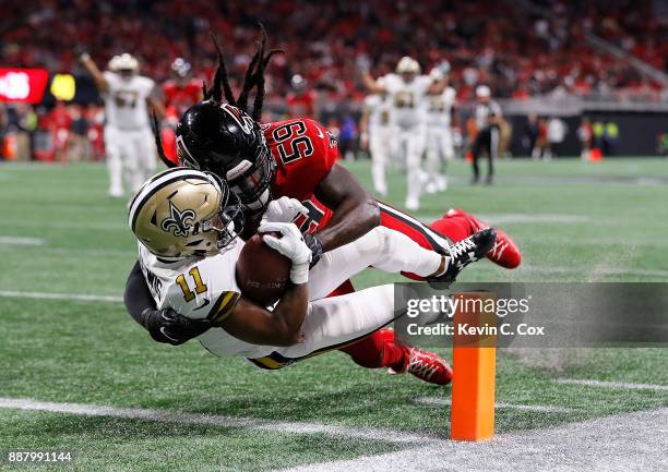 Tommylee Lewis of the New Orleans Saints dives for a touchdown as he is tackled by De'Vondre Campbell of the Atlanta Falcons at Mercedes-Benz Stadium...