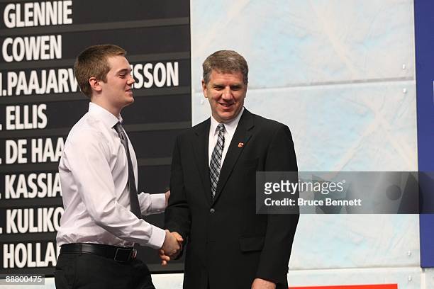 Director of Scouting Tod Button of the Calgary Flames shakes hands with draft pick Tim Erixon during the first round of the 2009 NHL Entry Draft at...