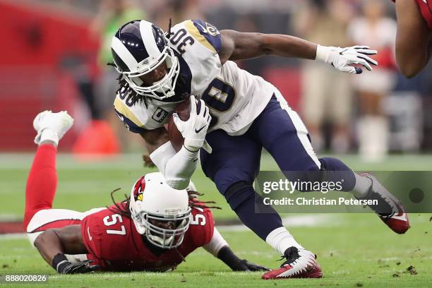 Running back Todd Gurley of the Los Angeles Rams rushes the football past linebacker Josh Bynes of the Arizona Cardinals during the NFL game at the...