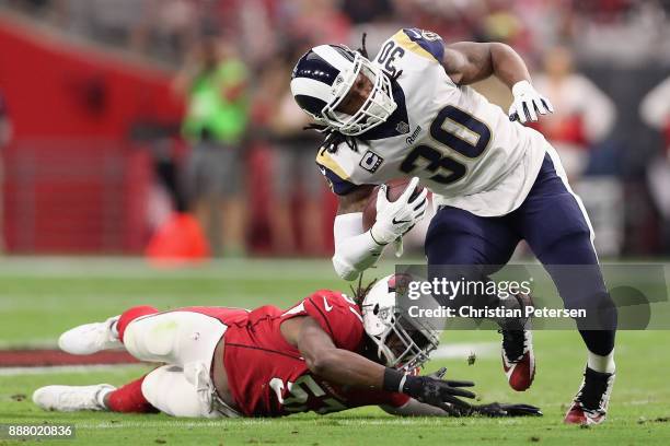 Running back Todd Gurley of the Los Angeles Rams rushes the football past linebacker Josh Bynes of the Arizona Cardinals during the NFL game at the...