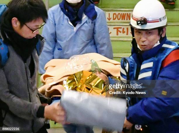 Man is taken away on a stretcher in the Hokkaido town of Kamikawa after his group of three Thais was rescued from a mountain on Dec. 8, 2017. They...