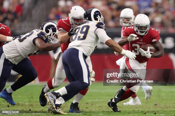 Running back Kerwynn Williams of the Arizona Cardinals rushes the football against defensive end Aaron Donald of the Los Angeles Rams during the NFL...