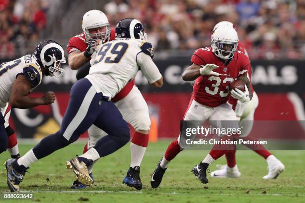 Running back Kerwynn Williams of the Arizona Cardinals rushes the football against defensive end Aaron Donald of the Los Angeles Rams during the NFL...