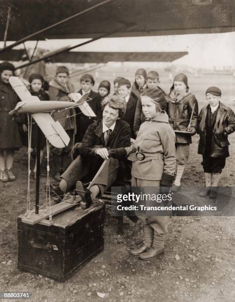 Aviatrix Amelia Earhart discusses aeronautics with young students from Newark, New Jersey in November in 1933.