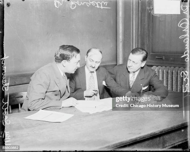 Portrait of Dr. Amante Rongetti , Dr. Orlando Scott, and attorney William Scott Stewart sitting at a table in a room in Chicago, Illinois, 1929....