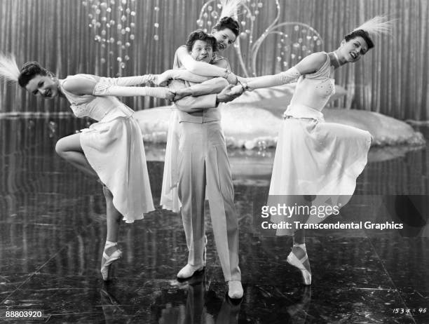 Actor and dancer Donald O'Connor performs in a scene with three female dancers around 1940 in Hollywood.