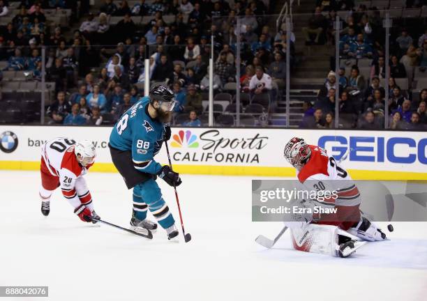 Brent Burns of the San Jose Sharks scores the game-winning goal on Cam Ward of the Carolina Hurricanes in overtime at SAP Center on December 7, 2017...