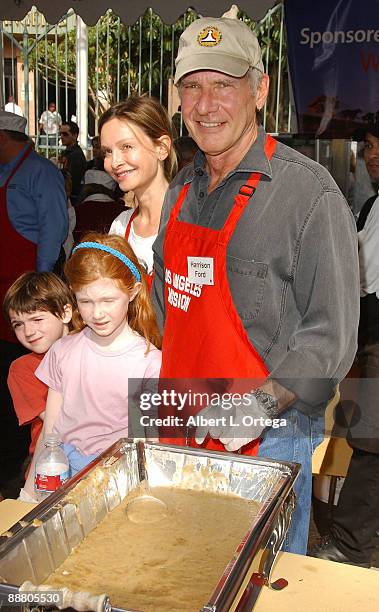 Actor Harrison Ford and actress Calista Flockhart with son Liam participate in serving Thanksgiving dinner to the Skid Row homeless at the Los...