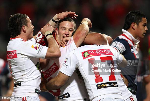 The Dragons celebrate with Neville Costigan after he scored a try during the round 17 NRL match between the St George Illawarra Dragons and the...