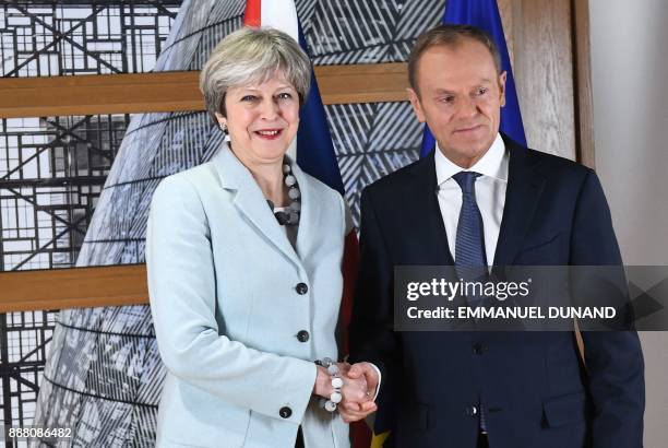 British Prime Minister Theresa May is welcomed by European Council President Donald Tusk at the European Council in Brussels on December 8, 2017....