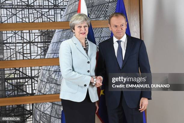 British Prime Minister Theresa May is welcomed by European Council President Donald Tusk at the European Council in Brussels on December 8, 2017....