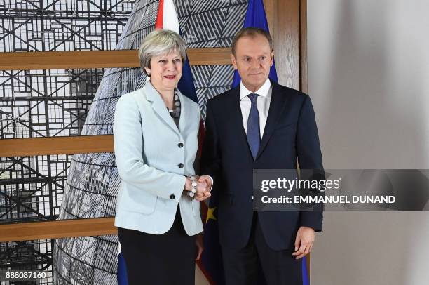 British Prime Minister Theresa May is welcomed by European Council President Donald Tusk at the European Council in Brussels on December 8, 2017....