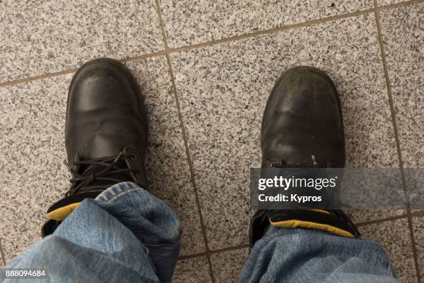 europe, austria, upper austria area, 2017: aerial view of man wearing leather work boots and denim jeans - stiefel-mit-stahlkappen stock-fotos und bilder