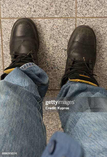 europe, austria, upper austria area, 2017: aerial view of man wearing leather work boots and denim jeans - stiefel-mit-stahlkappen stock-fotos und bilder