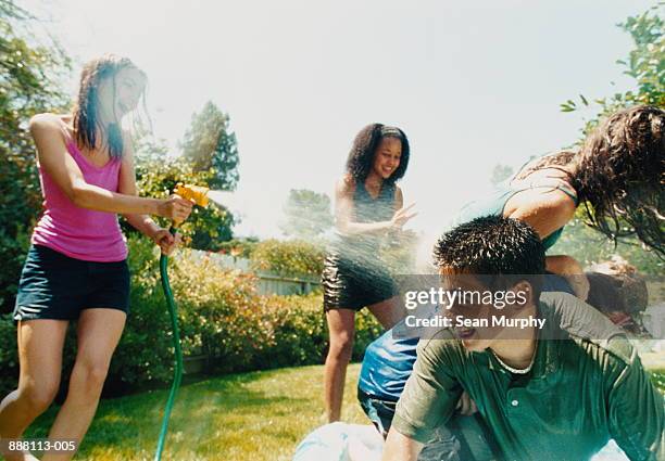 teenage boys and girls (14-16) outdoors getting wet with hose - wet hose ストックフォトと画像