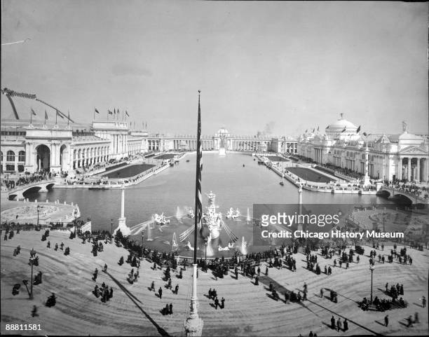 Expansive, eastward view showing people strolling and visiting along the Basin and the Court of Honor at the Chicago World's Columbian Exposition or...