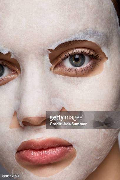 woman wearing a moisturizing sheet mask - peel off mask stock-fotos und bilder